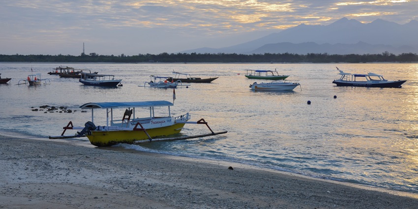 A picture of Trawangan Beach with boats parked at the shore, known for scuba diving