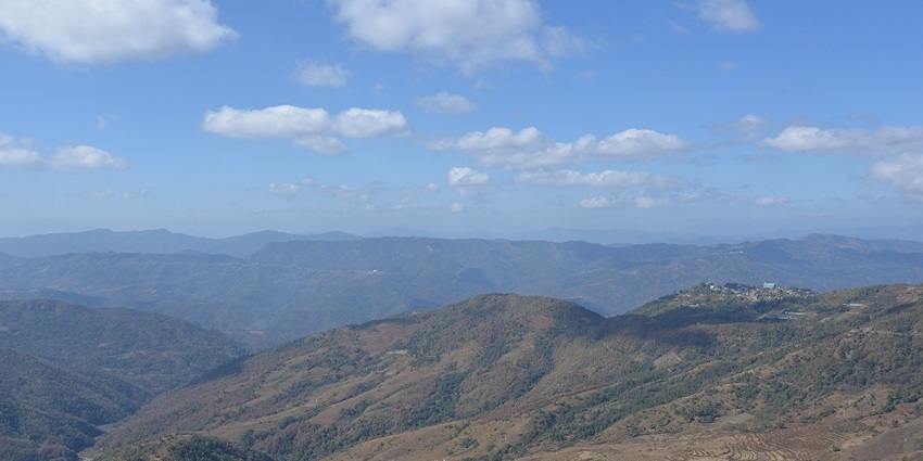 A scenic view from Hills in Ukhrul district, Manipur, India, showcasing a lush green valley with distant mountains