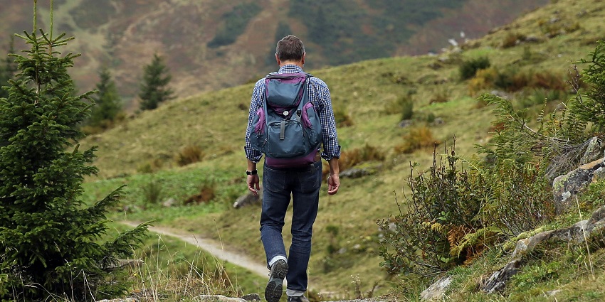 Man carrying a backpack walking on a trail in the Marat Longri Wildlife Sanctuary