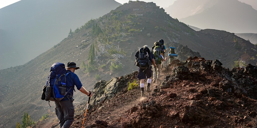 The beautiful snapshot of a group of travellers hiking on the mountainous hilly terrain