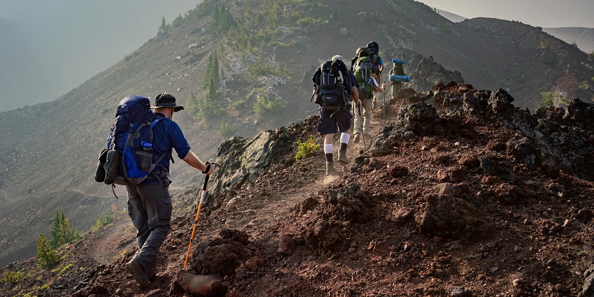 A group of friends hiking together on a mountain trail, enjoying nature and adventure.