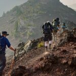 A view of hikers hiking through the unconventional trails surrounded by giant peaks.