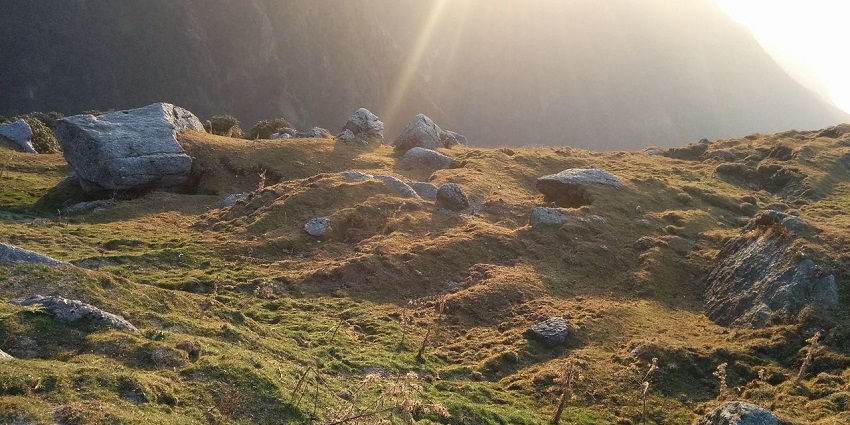 A stunning view of the Triund Hill, featuring lofty mountains and lush green vegetation.