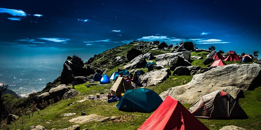 A scenic view of Triund hill campsite with tents - one of the best hill stations near Kangra.