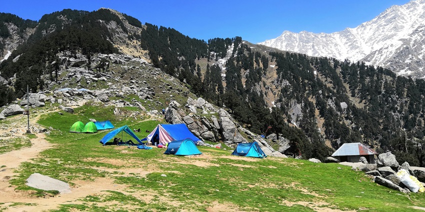 A mesmerising view of tents on the Triund Trek amidst the majestic Dhauladhar ranges