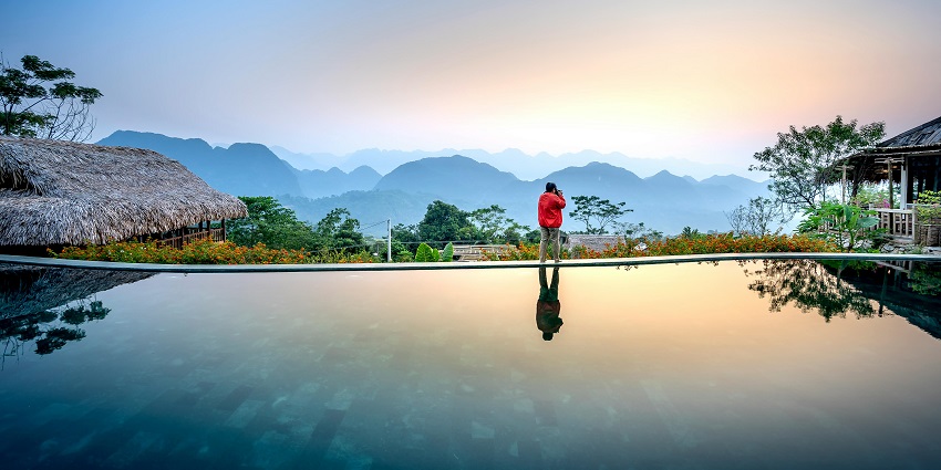 Tropical resort surrounded by lush greenery, with palm trees and a serene pool area.