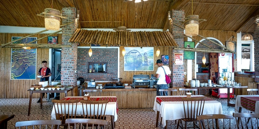 View of a tropical restaurant with ceiling, walls, and counter made out of bamboo sticks.
