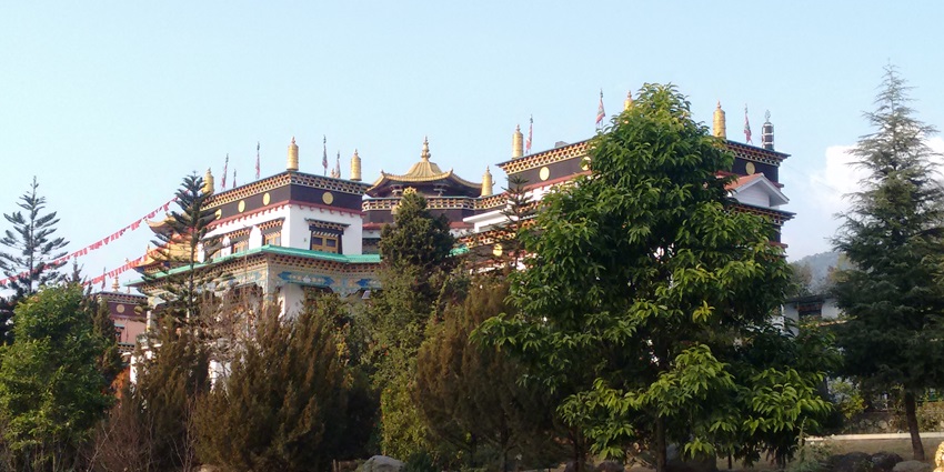 Traditional Tibetan architecture and vibrant prayer flags amidst a serene setting.