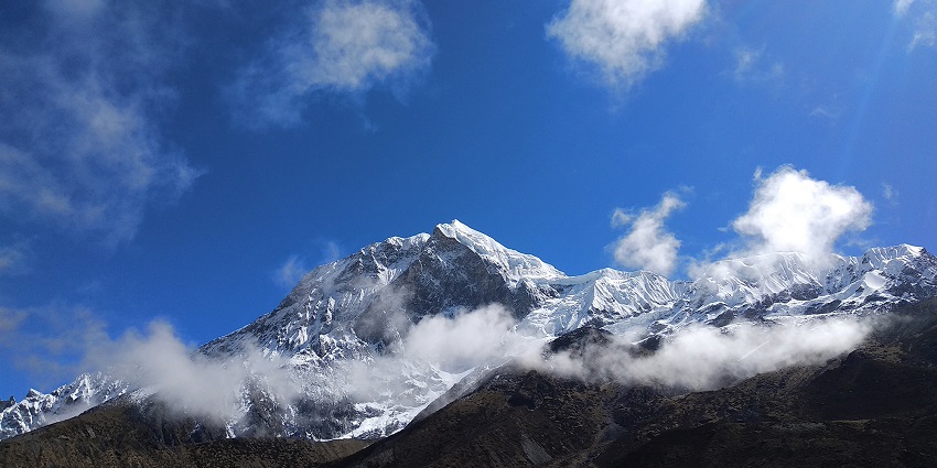 A breathtaking view of snow-capped Mount Pandim during the daytime under clouds.