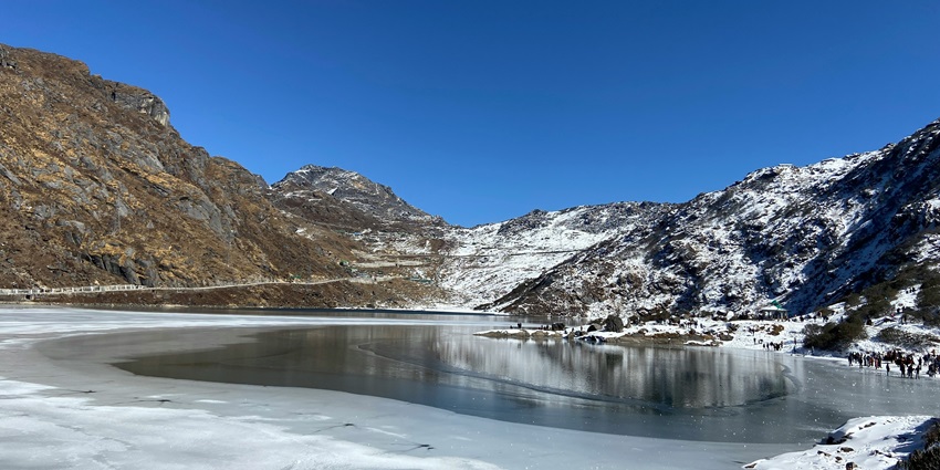 A breathtaking vista of Tsomgo Lake featuring glacial waters and majestic mountains.