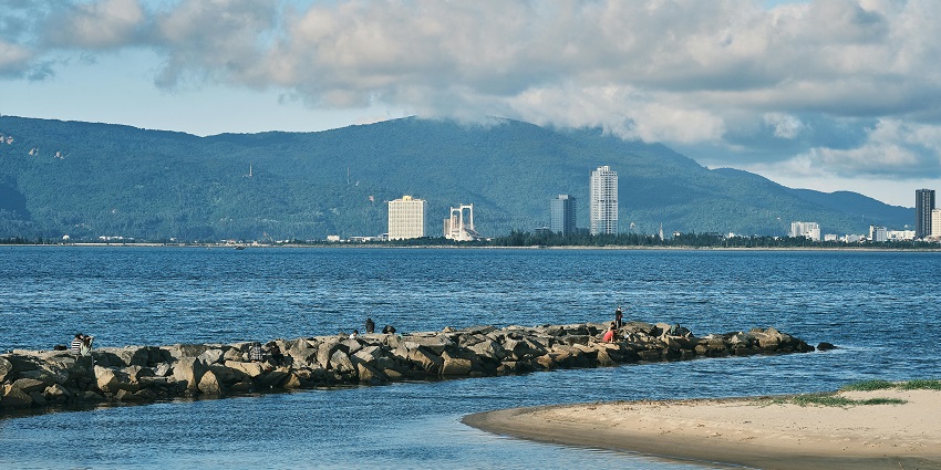 A stunning view of serene waters, rocky terrains, and majestic buildings of the region.