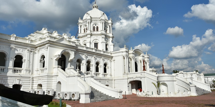 View of Ujjayanta Palace, showcasing its majestic structure and well-manicured grounds.