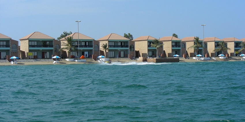 A picture of a seaside resort in Umm Al Quwain, with multiple shacks visible around the shore