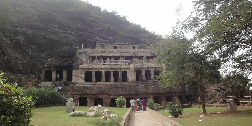View of the Undavalli Caves, showcasing intricate rock-cut architecture and lush surroundings.