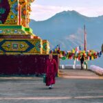 A stunning view of a red and yellow temple with colourful decorations during the day.