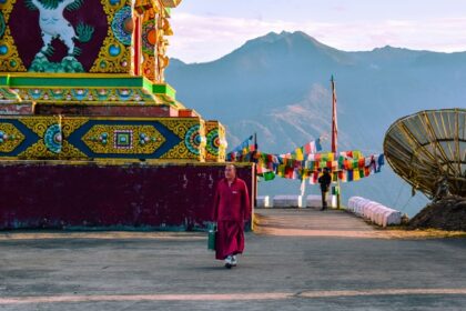 A stunning view of a red and yellow temple with colourful decorations during the day.