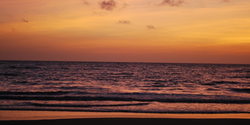 A picture of a beautiful sunset at the Devka beach with orange hues spreading all around