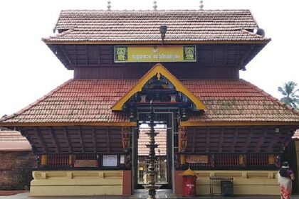 A frontal view of Valayanad Temple with red rood and yellow walls during the daytime.