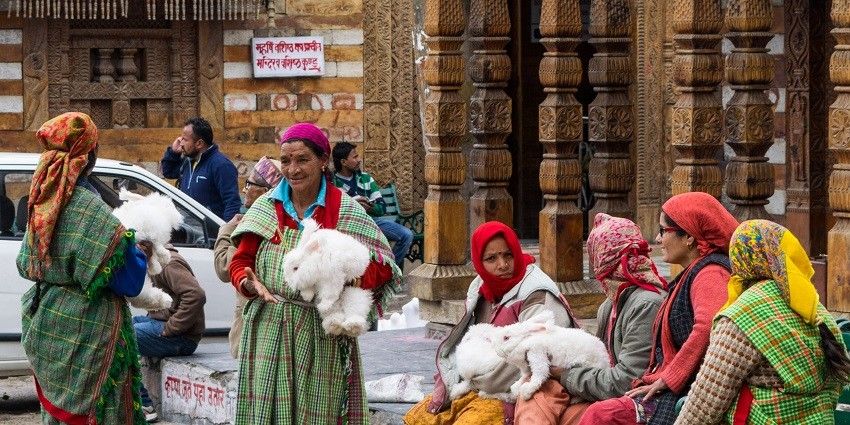 A picture of women standing outside an ancient holy shrine located in Himachal Pradesh.