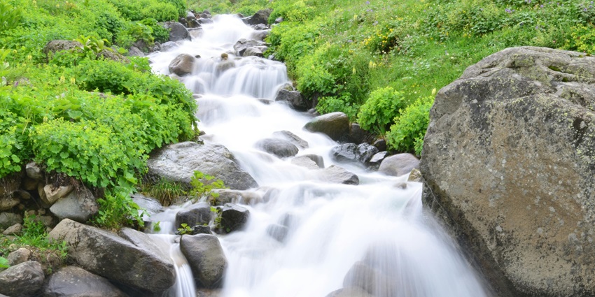 Image of a waterfall in a lush forest cascading water through rocks - beautiful waterfall in Kerala