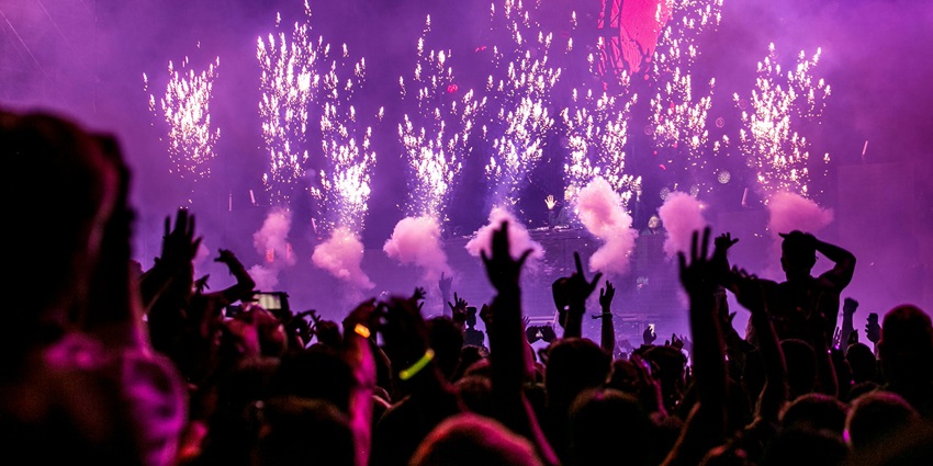 Purple fireworks effect lighting up the night sky with vibrant bursts of color.