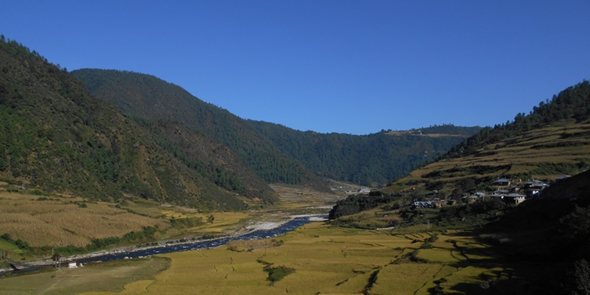 View of Dirang Valley, with terraced fields, winding rivers, and surrounding mountains.