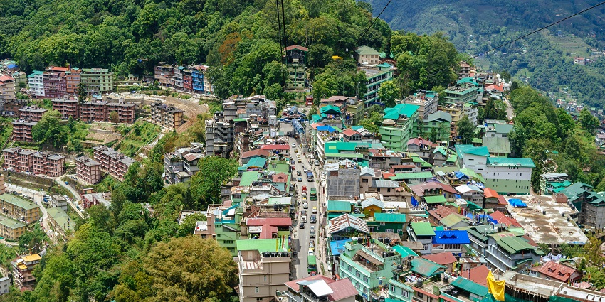 Showcasing the city's colorful buildings, winding roads, and surrounding mountain peaks.