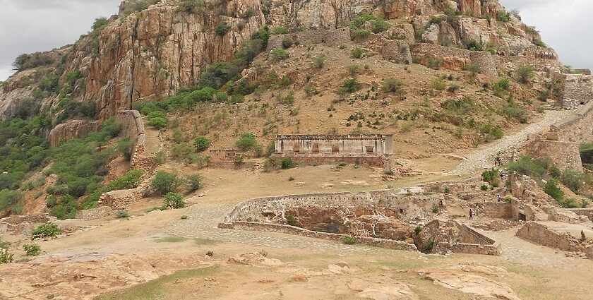 Image of ancient Gooty Fort above mountains, surrounded by rocks and lush greenery.