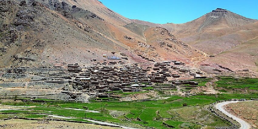 Picturesque traditional houses, lush green fields, and majestic Himalayan peaks.