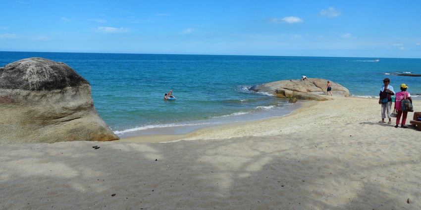 Image of serene Lamai Beach with soft sand, gentle waves, and lush greenery.