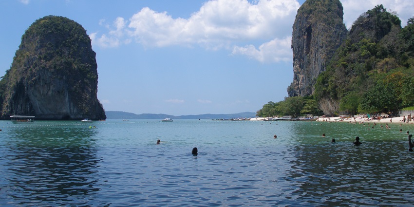 Railay Beach with stunning limestone cliffs, clear turquoise waters, and white sand.