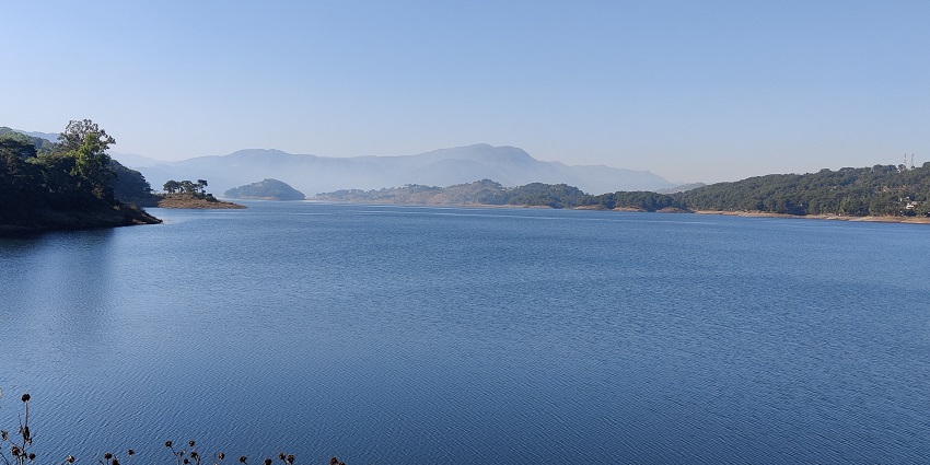 View of Umiam Lake with expansive blue waters, surrounded by lush hills and greenery.