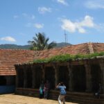 Thirunelli temple an ancient shrine set against a backdrop of lush greenery and hills.