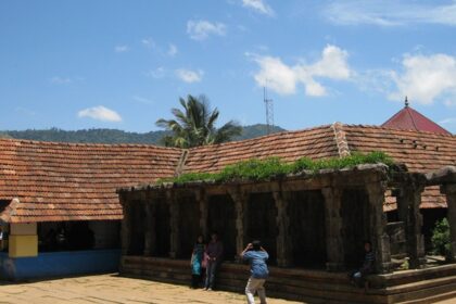 Thirunelli temple an ancient shrine set against a backdrop of lush greenery and hills.