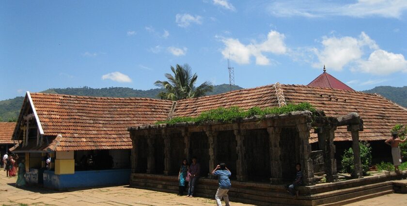 Thirunelli temple an ancient shrine set against a backdrop of lush greenery and hills.