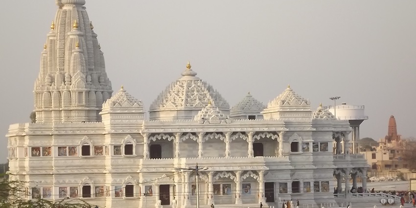 A picture of a traditional Hindu temple built using white marble and traditional Hindu architecture