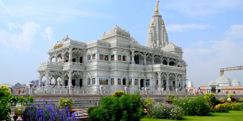Side view of Prem Mandir in Vrindavan with white marble and detailed carvings.