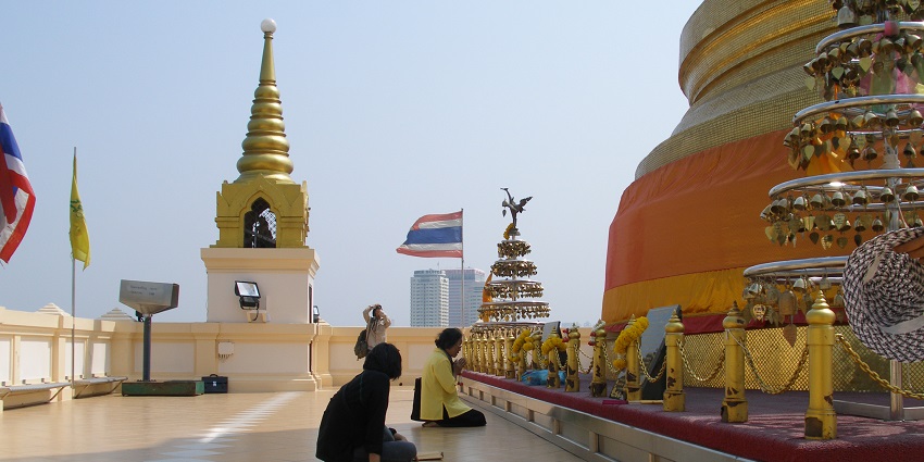 People praying in Wat Saket temple, one of the places to visit in Bangkok for couples