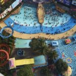 A bird-eye view of a massive water park with multiple slides and swimming pools