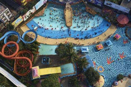 A bird-eye view of a massive water park with multiple slides and swimming pools