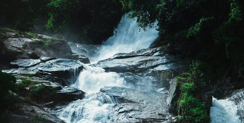 A breathtaking view of a small waterfall surrounded by lush greenery during the daytime.