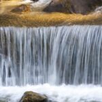 A breathtaking view of a majestic waterfall in Gangtok surrounded by lush greenery.