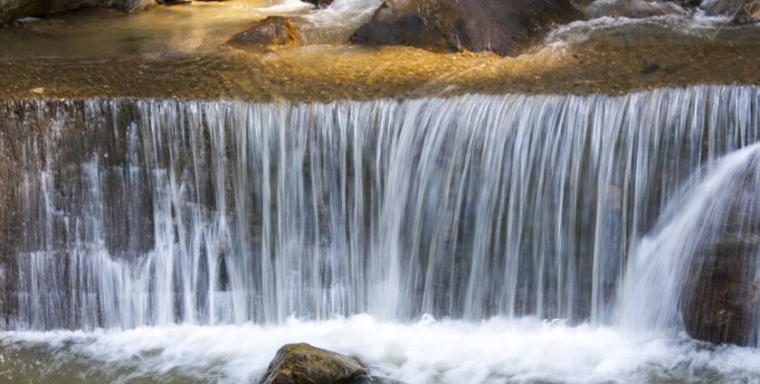 A breathtaking view of a majestic waterfall in Gangtok surrounded by lush greenery.