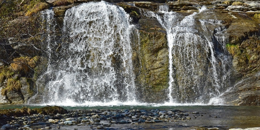Image of scenic waterfalls flowing over rugged rocks, creating a natural & dynamic scene.