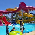 Water park in Thailand, colourful slides, pools, and fun water attractions under a sunny sky.