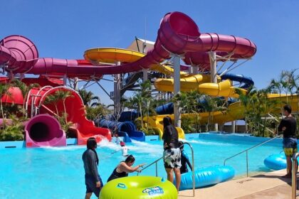 Water park in Thailand, colourful slides, pools, and fun water attractions under a sunny sky.