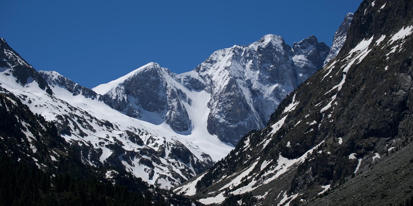 A majestic view of a mountain range covered in a thick blanket of snow during the day.