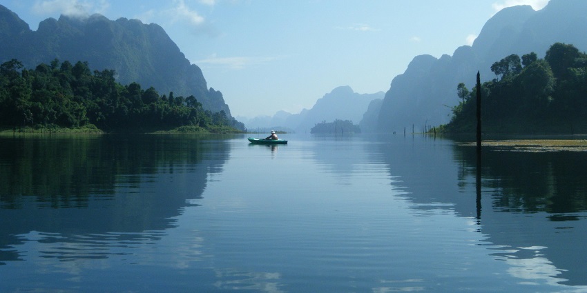 Man on a boat under a clear blue sky, enjoying a leisurely day on the water.
