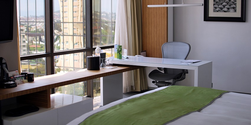 A picture of a hotel room in Meghalaya with a scenic view from the window