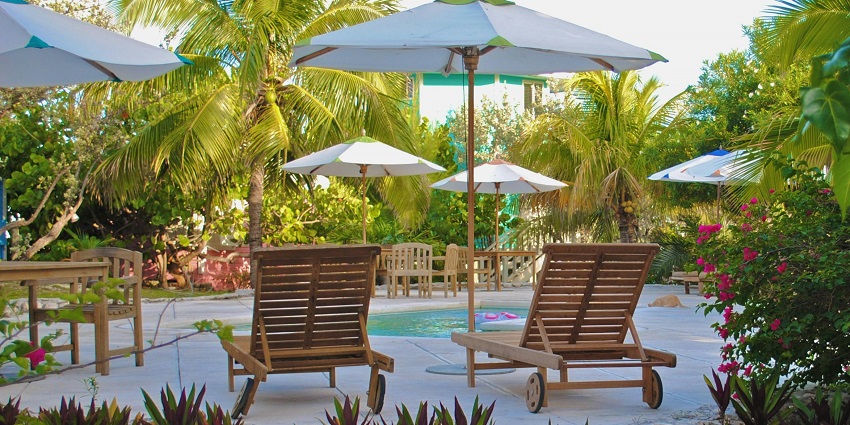 A picture from the garden area of a resort with chairs and umbrellas